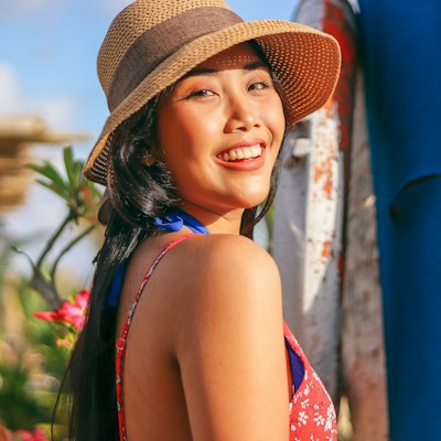 A smiling woman in a wide straw sun hat