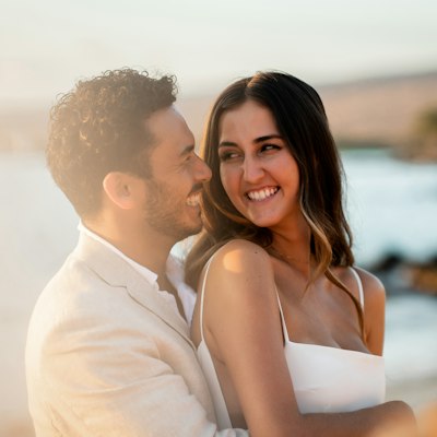 A smiling couple embracing by the sea